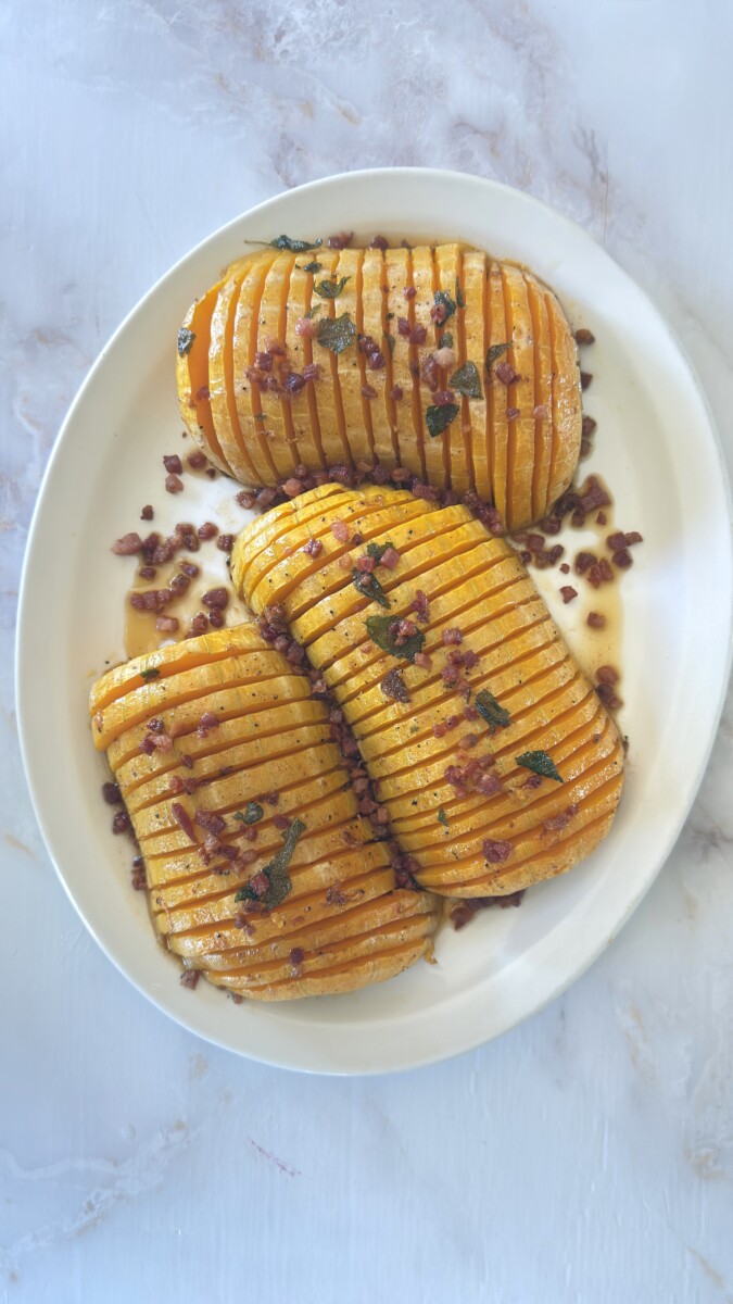 Transferring hasselback butternut squash to serving platter with wide spatula