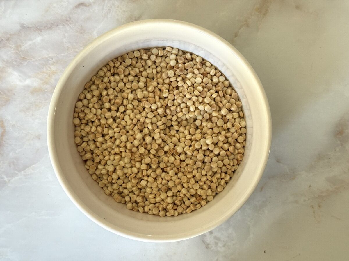 Golden toasted pearl couscous in a white bowl showing nutty color